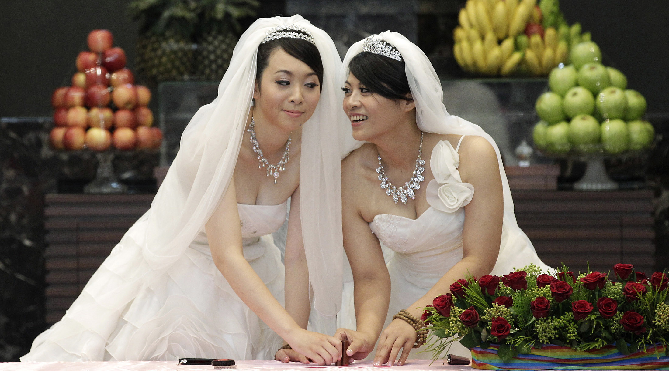 You Ya-ting, left, and Huang Mei-yu cast their stamps during their symbolic same-sex Buddhist wedding ceremony at a temple in Taoyuan county, northern Taiwan, on Aug. 11, 2012. You Ya-ting, left, and Huang Mei-yu cast their stamps during their symbolic same-sex Buddhist wedding ceremony at a temple in Taoyuan county, northern Taiwan, on Aug. 11, 2012.
